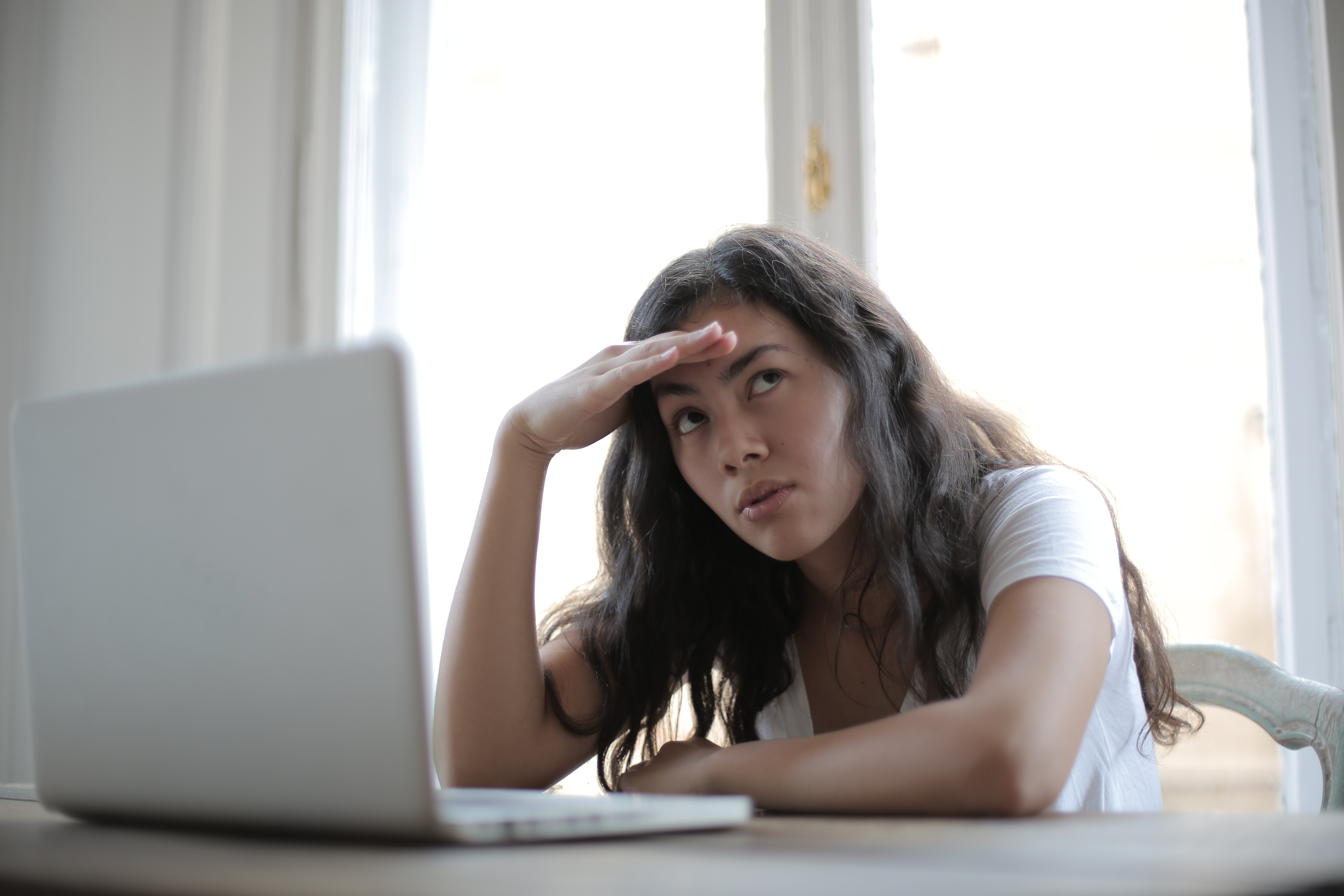 image of a women frustrated whilst looking at a laptop screen.